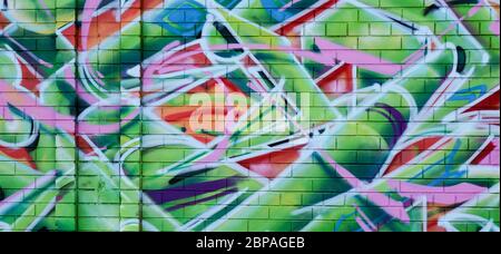 Abstract colorful graffiti background wall featuring urban art work with colors of green, white, pink, orange, yellow and blue. Stock Photo