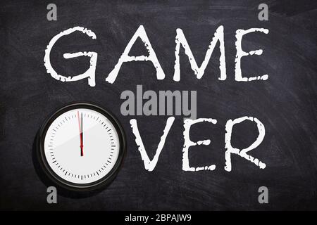 Game over handwritten text written with white chalk on chalkboard or blackboard.Time is over concept. Stock Photo