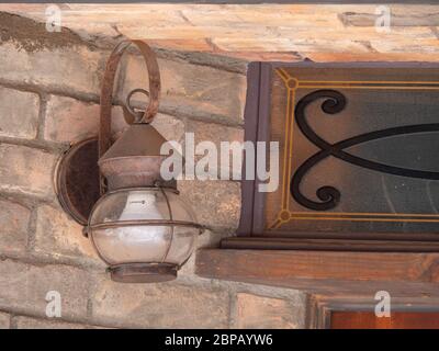 Old electric lamp hanging on a brick wall. Stock Photo
