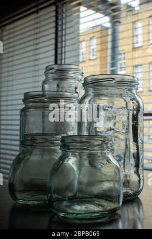 High angle close up of empty glass jars with wooden wicks, for candle making.  Stock Photo by Mint_Images