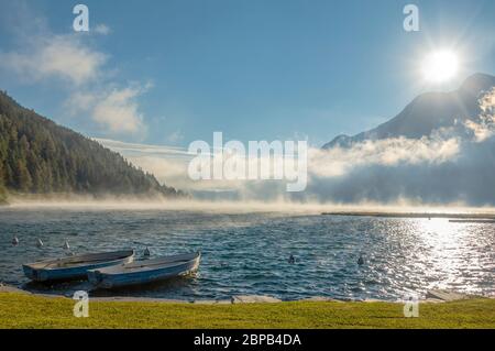 Rowing boats on a spring morning at Lake Silverplana near Sils Maria, Engadin, Grisons, Switzerland Stock Photo