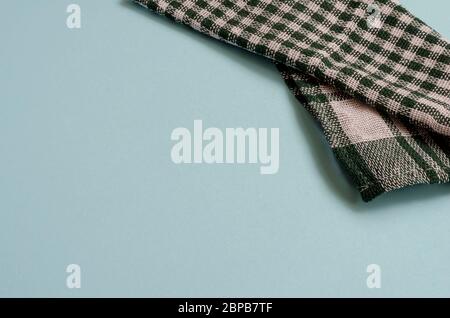 Creative Light turquoise background with a green checkered towel. A kitchen towel folded randomly. Minimalistic multitask background with place for te Stock Photo