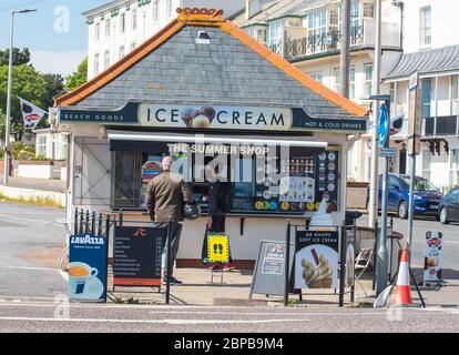 Sidmouth, East Devon, UK. 18th May, 2020. UK Weather: Families and couples enjoy a hot and sunny afternoon along the esplanade at the elegant regency town of Sidmouth. Temperatures are set to rise further this week as high pressure dominates bringing a mini-heatwave to many parts of the UK. Credit: DWR/Alamy Live News Stock Photo