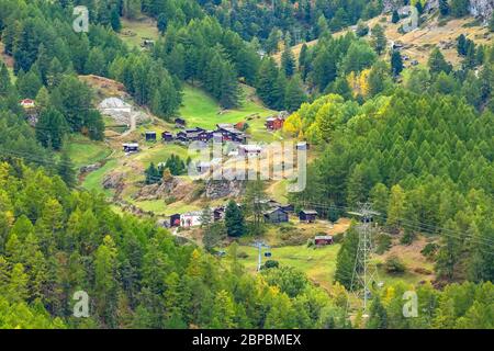 Beautiful alpine village in the pine woods, Switzerland, Swiss Alps near Zermatt and cable car cabins Stock Photo