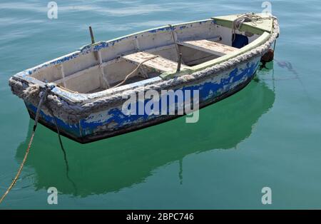 A small rowboat floats in the harbour at Marsaxlokk, a traditional fishing village on the southeast coast of the island of Malta.