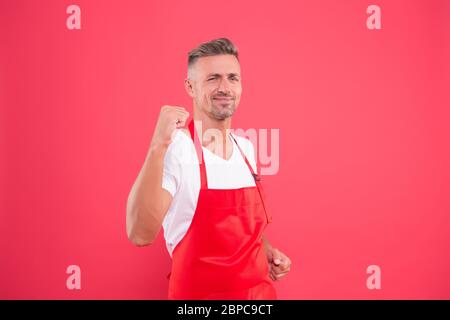 yes, we did it. cheerful mature waiter celebrate success. waiter in a restaurant. he will take the order. best waiter service. handsome waiter in red apron. Successful small business owner. Stock Photo