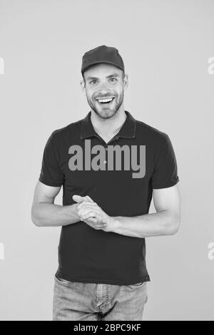 Shop worker. Handsome guy cashier uniform. Restaurant cafe staff wanted. Welcome. Supermarket cashier. Man delivery service wear red cap. Shop assistant. Food order delivery man. Cashier occupation. Stock Photo