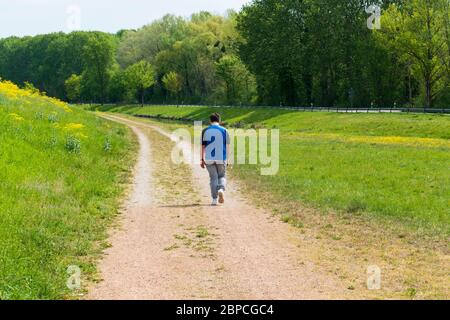 Junger Mann läuft traurig einen Weg entlang Stock Photo