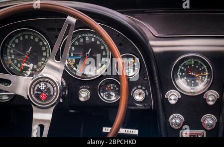 TORONTO, CANADA - 08 18 2018: Steering wheel with logo on horn button, dials and knobs on front panel of 1966 Chevrolet Corvette Sting Ray oldtimer Stock Photo