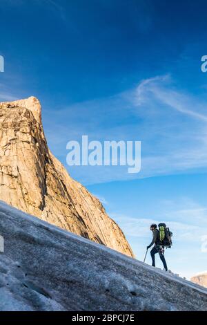 Backpacker ascending glacier on Baffin Island, Canada. Stock Photo