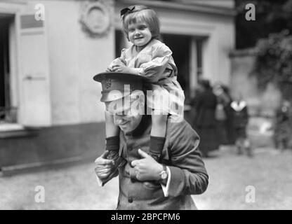 Little Belgian Refugee Girl having on Shoulders of American Red Cross Man at American Hostel for Refugees, 46 Rue du Dr. Blanche, Paris, France, Lewis Wickes Hine, American National Red Cross Photograph Collection, June 1918 Stock Photo