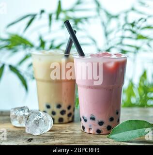 two plastic cups of iced bubble tea on wooden table Stock Photo