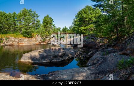 Victoria Falls Conservation Area  showing main bridge, two tone textured rocks and green forest on a sunny summer gorgeous day Stock Photo