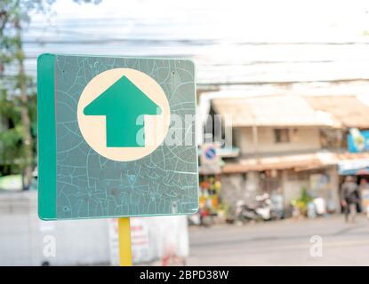 The green metal exit sign standing on the outside of the parking car at the department store. Stock Photo