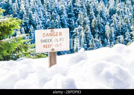 danger sheer cliff keep off sign on the edge of land cover with snow.. Stock Photo