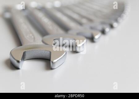 Spanners. Many wrenches. Grey background. Set of wrenches in different sizes on grey background.Close up. Blurred background. Stock Photo