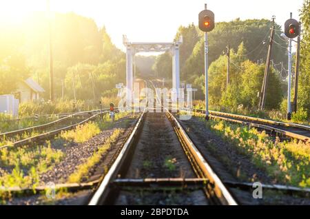 Railroad against beautiful sky at sunset. Rural landscape with railway station Stock Photo