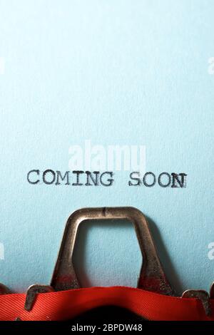 Coming soon text written on a paper. Stock Photo