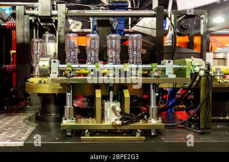 Plastic bottles ready to be filled on a bottling line of automatic PET/plastic bottle blow moulding machine. Stock Photo