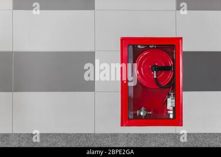 Hydrant with water hoses and fire extinguish equipment on the wall in an corridor. Stock Photo