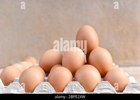 Egg, Chicken Egg. Close-up view of raw Brown chicken eggs in egg box on Cement floor background. Selected focus Stock Photo