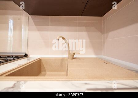 Sink with faucet in an empty kitchen in an apartment. Selective focus. Stock Photo