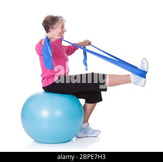Senior Woman Stretching Exercising Equipment On White Background Stock Photo