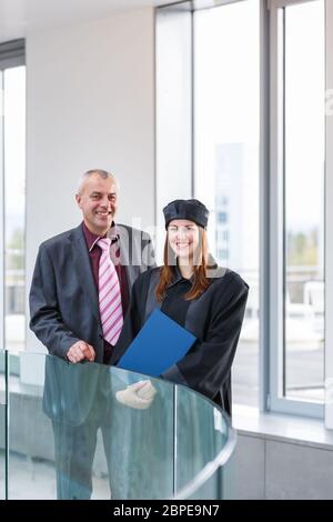 Pretty female university graduate with her happy and proud father, moments after getting the diploma Stock Photo
