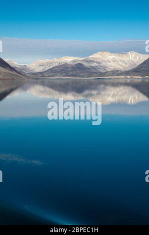 Abendstimmung an Bord eines Kreuzfahrtschiffs in den Fjorden Norwegens mit Spiegelung der Berge im Wasser Stock Photo