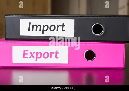 Bright office folders over dark background and import export text concept Stock Photo
