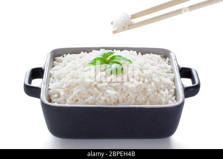 Rice with basil eaten from ceramic bowl with wooden chopsticks, isolated on the white background, clipping path included. Stock Photo