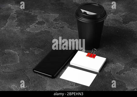 Mock up of blank business card and black smartphone screen on table Stock Photo