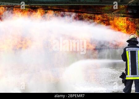 Feuerwehr sprüht Löschwasser aus Feuerwehrschlauch während eines Waldbrandes. Stock Photo