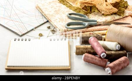 Accessories for sewing and cutting lie on a white table.  Space for an object. Stock Photo