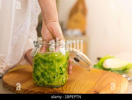 Preparing fermented preserved vegetables. Jars of cabbage kimchi and sauerkraut sour cabbage. Stock Photo