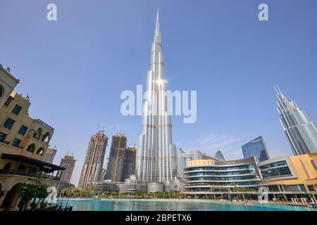 DUBAI, UNITED ARAB EMIRATES - NOVEMBER 19, 2019: Burj Khalifa skyscraper with sun reflection, Dubai Mall and artificial lake in a sunny day