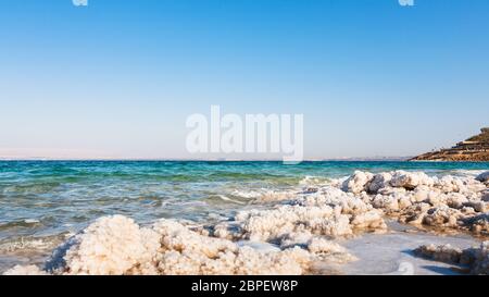 Travel to Middle East country Kingdom of Jordan - natural salt close up on shore of Dead Sea in sunny winter day Stock Photo
