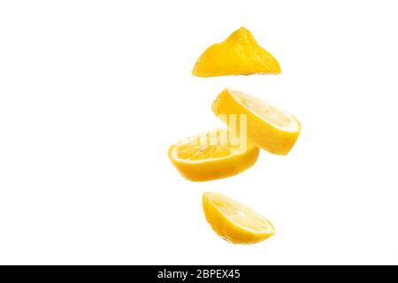 Sliced lemon floating on white background. Fruit slice falling on bright backdrop. Stock Photo