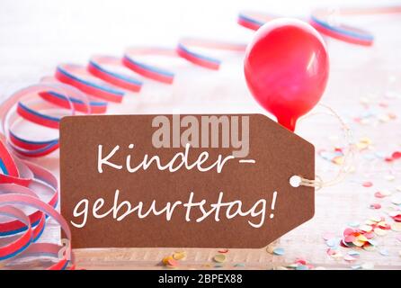 One Label With German Text Kindergeburtstag Means Birthday Party. Party Decoration Like Streamer, Confetti And Balloon. Wooden Background With Vintage Stock Photo