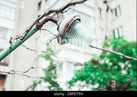 old rusty street lamp on a barbed wire fence Stock Photo