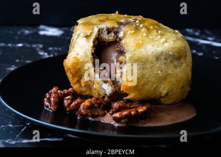 Fried Ice Cream with Chocolate and Roasted Walnuts in Dark Black Plate. Traditional Organic Dessert. Stock Photo