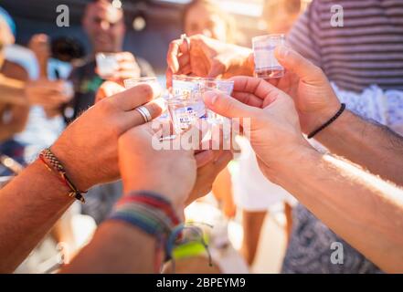 Closeup photo of a men hands with glass full of alcoholic drink, speaking toast, cheers, celebrating holiday, open air party, happy summer vacation Stock Photo