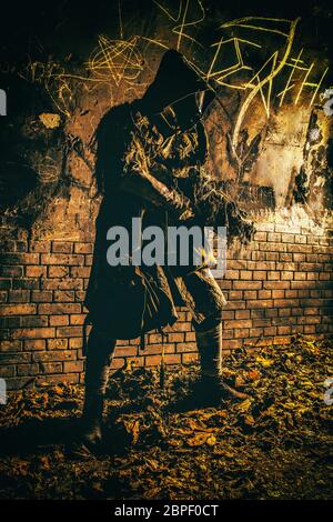 Post apocalyptic survivor, living underground mutant, wearing tattered rags hiding in deep bunker, city tunnel or catacombs, sneaking in dungeon with Stock Photo