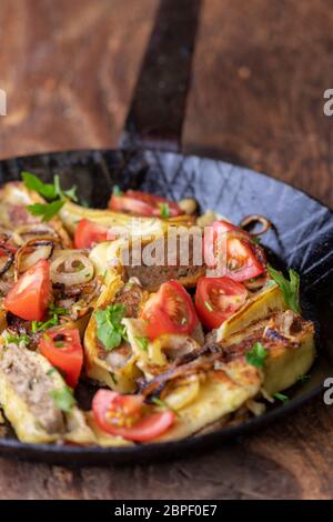 swabian maultasche with onions in an iron pan Stock Photo