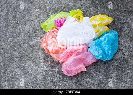 Colorful plastic bags on cement floor background. Stock Photo