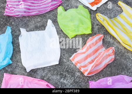 Colorful plastic bags on cement floor background. Stock Photo