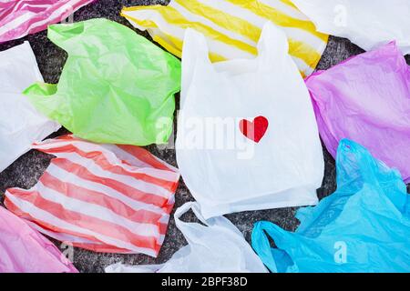 Colorful plastic bags on cement floor background. Stock Photo