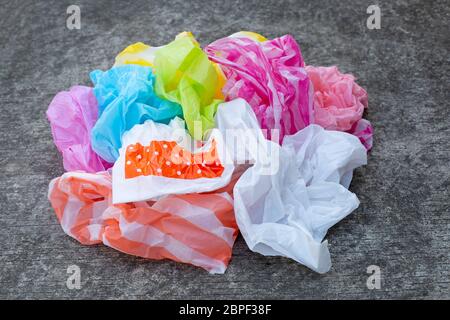 Colorful plastic bags on cement floor background. Stock Photo