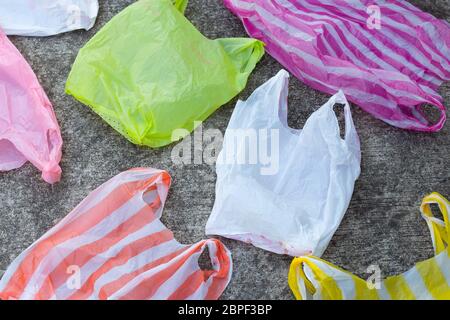 Colorful plastic bags on cement floor background Stock Photo