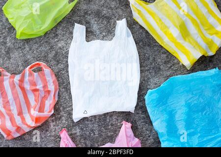 Colorful plastic bags on cement floor background Stock Photo